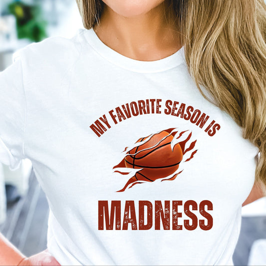 Woman wearing a white t-shirt with a basketball graphic and text.